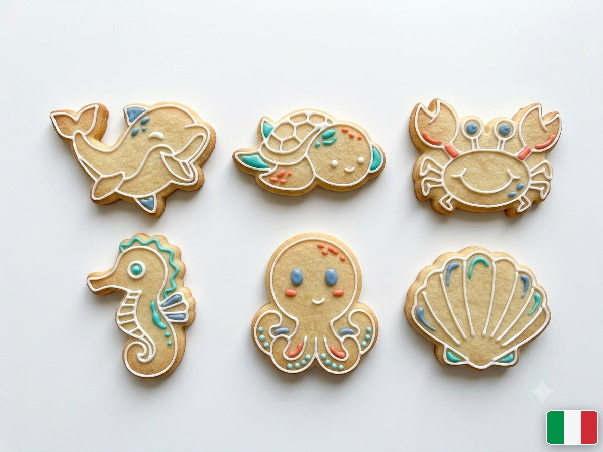 Biscotti a tema mare decorati con ghiaccia bianca e accenti azzurri e corallo