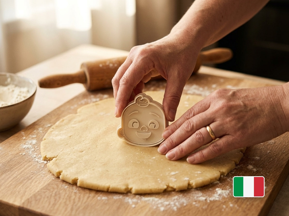 Mani che usano il tagliabiscotti Cocomelon sull'impasto
